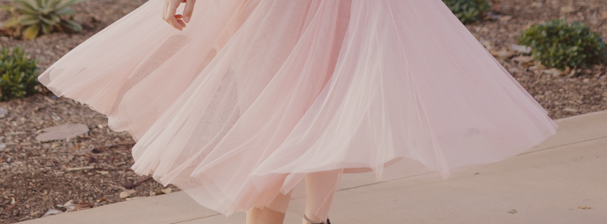 Pink dress with a flowing skirt on a blurred outdoor background